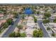 Aerial view of a neighborhood with manicured lawns, mature landscaping, and a community lake at 869 W Shellfish Dr, Gilbert, AZ 85233