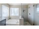 This renovated bathroom features a soaking tub and glass-enclosed shower with bench at 869 W Shellfish Dr, Gilbert, AZ 85233