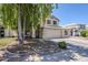 Inviting home exterior featuring a well-kept lawn, mature trees, and a welcoming entrance at 869 W Shellfish Dr, Gilbert, AZ 85233