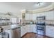 Bright kitchen featuring stainless steel appliances, a stone countertop island, and a view to the living room at 869 W Shellfish Dr, Gilbert, AZ 85233