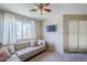Living room with a light sofa, ceiling fan, mounted tv, and bright window at 869 W Shellfish Dr, Gilbert, AZ 85233
