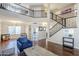 Open-concept living room with hardwood floors, high ceilings, wrought iron railings, and bright natural light at 869 W Shellfish Dr, Gilbert, AZ 85233