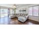 Bright living room featuring a gray sectional sofa, wood floors, and sliding glass doors to the backyard at 869 W Shellfish Dr, Gilbert, AZ 85233