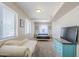 Spacious bedroom with two bright windows, couch, and TV at 869 W Shellfish Dr, Gilbert, AZ 85233