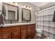 Comfortable bathroom showcasing a double sink vanity with granite countertops and a tiled floor at 9121 E Karen Dr, Scottsdale, AZ 85260