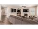 Open concept living room with a fireplace, two TVs, tiled flooring, and a sectional sofa at 9121 E Karen Dr, Scottsdale, AZ 85260