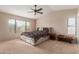 Relaxing main bedroom with a cozy seat, ceiling fan and bright light from the large windows at 9121 E Karen Dr, Scottsdale, AZ 85260