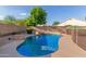 Sparkling pool with a rock waterfall feature and safety fence at 9121 E Karen Dr, Scottsdale, AZ 85260