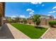 Landscaped backyard with artificial turf, stone accents, and privacy fence at 9452 W Parkside Ln, Peoria, AZ 85383