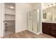 Bathroom with a large glass enclosed shower, wood look tile, and granite countertop at 9452 W Parkside Ln, Peoria, AZ 85383