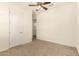 Bedroom featuring neutral carpet, ceiling fan, and ensuite bathroom access at 9452 W Parkside Ln, Peoria, AZ 85383