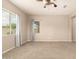 Bright bedroom with neutral carpet, three windows, and a modern ceiling fan at 9452 W Parkside Ln, Peoria, AZ 85383