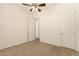 Bedroom featuring neutral carpet, ceiling fan, and ensuite bathroom access at 9452 W Parkside Ln, Peoria, AZ 85383