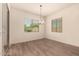 Bright dining room featuring wood-look tile flooring and a modern chandelier at 9452 W Parkside Ln, Peoria, AZ 85383