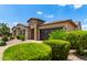 Single-story home with manicured desert landscaping, stone accents, and a dark two-car garage door at 9452 W Parkside Ln, Peoria, AZ 85383