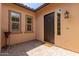 Covered front porch with a dark front door, brick pavers, and sidelight windows at 9452 W Parkside Ln, Peoria, AZ 85383