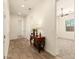 Hallway with wood look tile flooring, neutral walls, and decorative table at 9452 W Parkside Ln, Peoria, AZ 85383