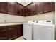 Laundry room with built-in cabinets, sink, and modern appliances at 9452 W Parkside Ln, Peoria, AZ 85383