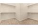 Spacious walk-in closet with carpeted flooring and multiple rows of shelving for storage at 9452 W Parkside Ln, Peoria, AZ 85383