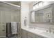 Updated bathroom featuring double sinks, a framed mirror, modern lighting, and a glass-enclosed shower, offering convenience at 10490 E Morning Star Dr, Scottsdale, AZ 85255
