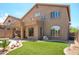 Home's backyard with synthetic grass, desert landscaping, and a covered patio at 10490 E Morning Star Dr, Scottsdale, AZ 85255