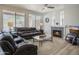 Comfortable living room featuring leather sofas, a fireplace, and large windows overlooking the yard at 10490 E Morning Star Dr, Scottsdale, AZ 85255