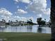 Picturesque view of homes along the serene lake, enhanced by palm trees and boat docks at 1121 W Windjammer Dr, Gilbert, AZ 85233