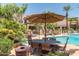 Serene community pool area surrounded by lush landscaping, shaded dining, and lounge chairs at 11375 E Sahuaro Dr # 2015, Scottsdale, AZ 85259