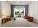 Bright living room featuring neutral carpet, modern decor, and a view of the backyard pool at 11403 E Caron St, Scottsdale, AZ 85259