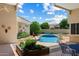 Covered patio with comfortable seating area overlooks a serene pool and well-maintained landscaping at 11403 E Caron St, Scottsdale, AZ 85259