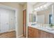 Clean bathroom showcases wood cabinetry, double sinks, and a large mirror at 11640 N Tatum Blvd # 2013, Phoenix, AZ 85028