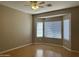 The bedroom offers natural light with bay windows and finished with wood laminate flooring at 11921 W Madison St, Avondale, AZ 85323