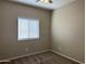 Neutral bedroom with plush carpet, a bright window, and a ceiling fan for comfortable living at 11921 W Madison St, Avondale, AZ 85323