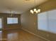 Dining area with tiled flooring, a modern chandelier, a ceiling fan and sliding glass doors to the backyard at 11921 W Madison St, Avondale, AZ 85323