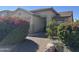Inviting single-story home with desert landscaping, including bright pink bougainvillea, along the front yard at 11921 W Madison St, Avondale, AZ 85323