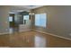 Open-concept living room with hardwood floors, large windows, and an archway leading to the dining area at 11921 W Madison St, Avondale, AZ 85323