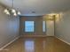 Bright living room featuring hardwood floors, a large window, and a white front door with glass panel at 11921 W Madison St, Avondale, AZ 85323