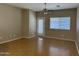 Bright living room featuring hardwood floors, a ceiling fan, and sliding glass doors to the backyard at 11921 W Madison St, Avondale, AZ 85323