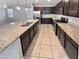 Stylish kitchen features granite counters, stainless appliances, dark wood cabinets and tile floors at 12211 W Prickly Pear Trl, Peoria, AZ 85383