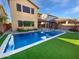 Inviting backyard with a sparkling pool, artificial grass, and a covered patio at 12211 W Prickly Pear Trl, Peoria, AZ 85383