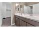 Bathroom featuring double sinks, wood cabinets, and access to walk-in closet at 1255 N Arizona Ave # 1251, Chandler, AZ 85225