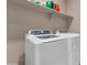 Modern laundry room with front loading washer and dryer and shelf storage above at 1255 N Arizona Ave # 1251, Chandler, AZ 85225