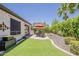 Backyard with artificial grass, patio with dining set under umbrella, and desert landscaping for low maintenance at 12738 W Brookhart Way, Peoria, AZ 85383