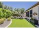 Serene backyard featuring artificial turf, mature trees, and privacy landscaping at 12738 W Brookhart Way, Peoria, AZ 85383