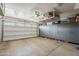 Well-maintained garage with epoxy flooring and custom cabinets providing ample storage solutions and organization at 12738 W Brookhart Way, Peoria, AZ 85383