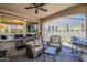 Inviting covered patio featuring wicker furniture, a ceiling fan, and serene views of the landscaped backyard oasis at 12738 W Brookhart Way, Peoria, AZ 85383