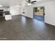 Inviting living space with tile floors, bright white walls and a ceiling fan, adjacent to a kitchen with stainless steel appliances at 12801 N El Frio St, El Mirage, AZ 85335