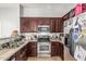 Kitchen with stainless steel appliances, granite countertops, and dark wood cabinetry at 1350 S Greenfield Rd # 2159, Mesa, AZ 85206