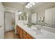 Bathroom with dual sinks, a large mirror, and tile flooring at 13633 W Alvarado Dr, Goodyear, AZ 85395