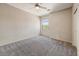 A standard bedroom features neutral paint, carpet, a ceiling fan, and a window at 13633 W Alvarado Dr, Goodyear, AZ 85395